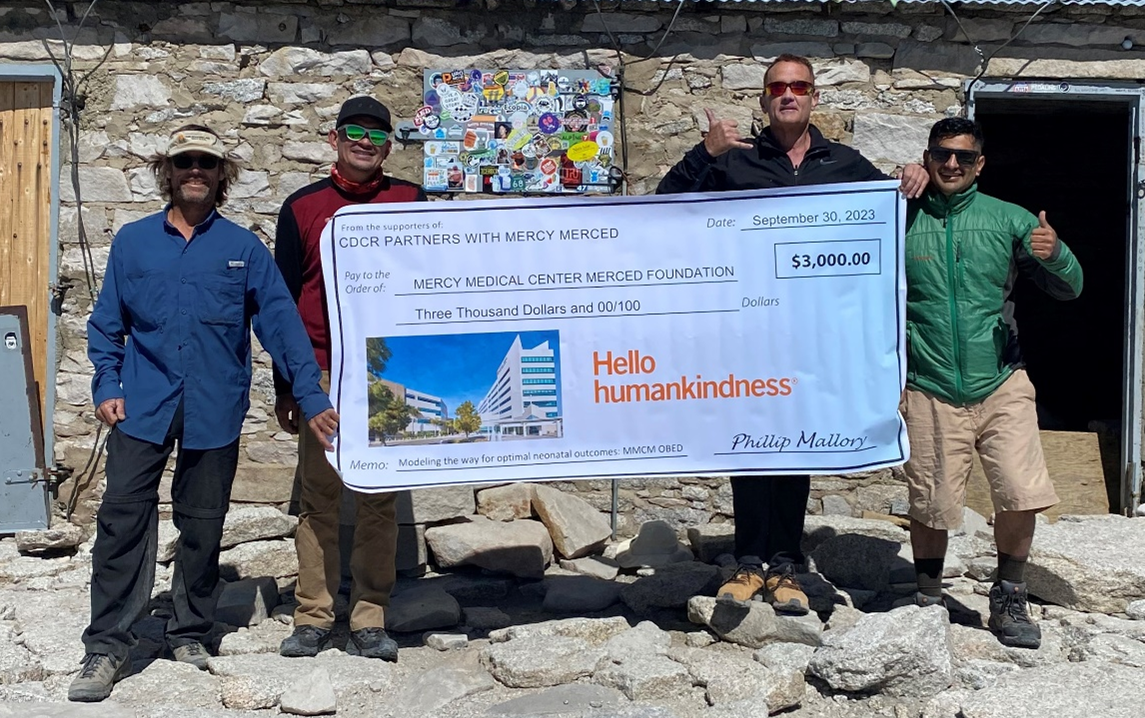 Picture of hikers with giant check for Mercy Merced