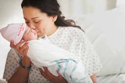 mom kissing newborn