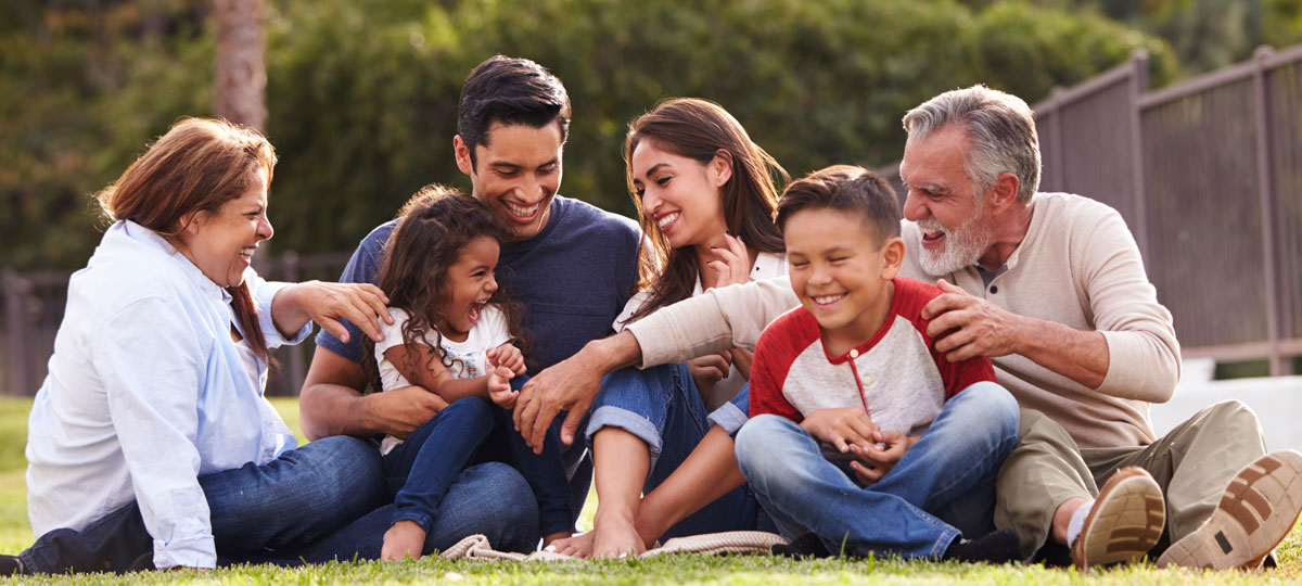 family sitting on grass laughing